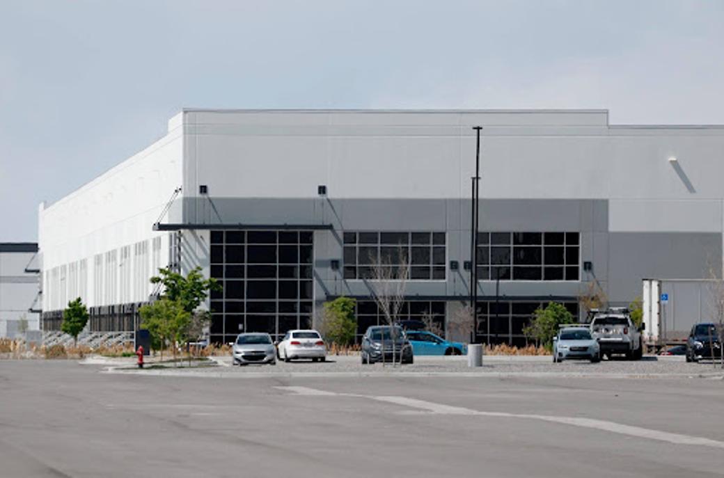 Exterior view of white and grey warehouse in Salt Lake City with cars in the parking lot