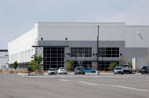 Exterior view of white and grey warehouse in Salt Lake City with cars in the parking lot