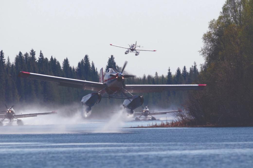 A firefighting plane flies close to the lake’s surface.