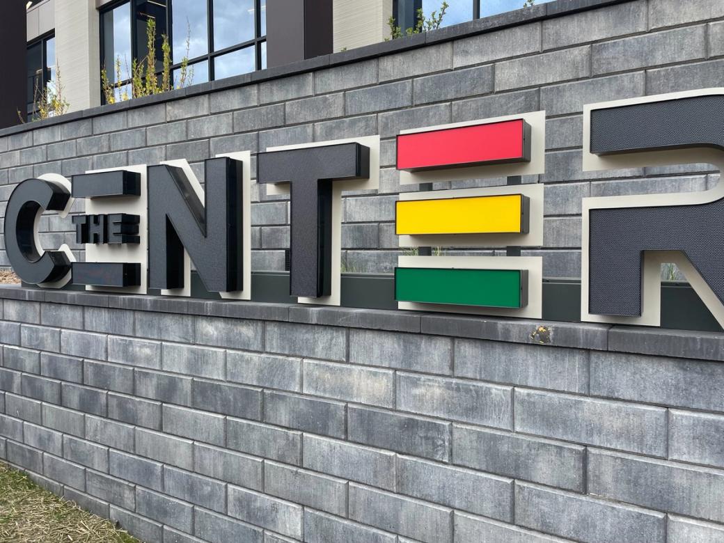 A stone sign spelling out "CENTER" against a gray wall.