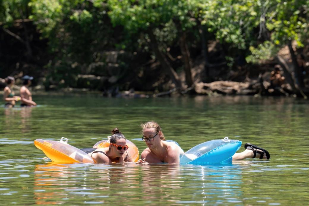 Two people on floaties in a lake.