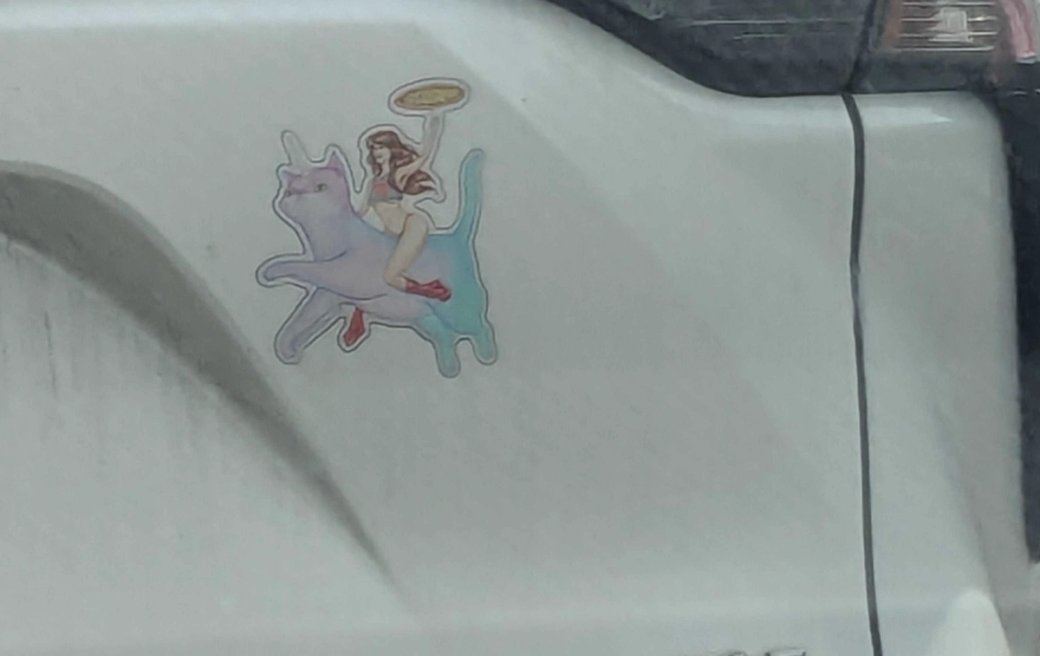 bumper sticker decal of a pastel-rainbow-colored cat with a woman superhero holding a pizza