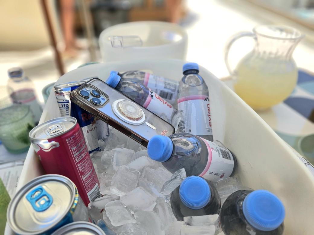 A phone with drinks in an ice bucket. 