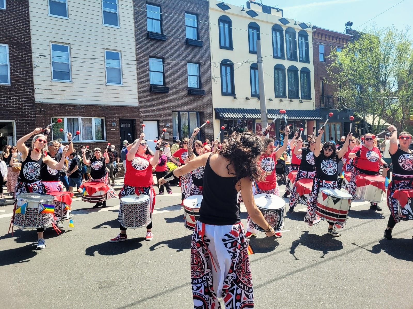 A drum line dancing at a street festival.