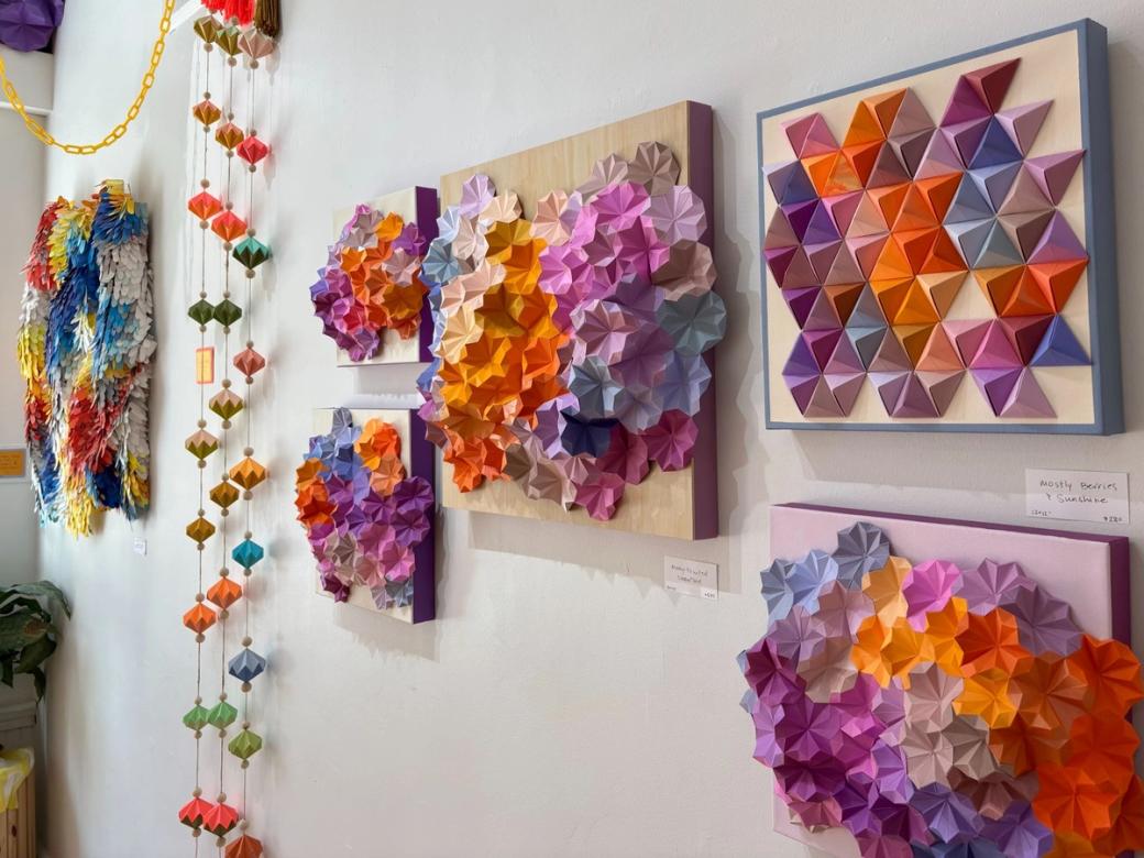 Colorful geometric art pieces on a white wall.