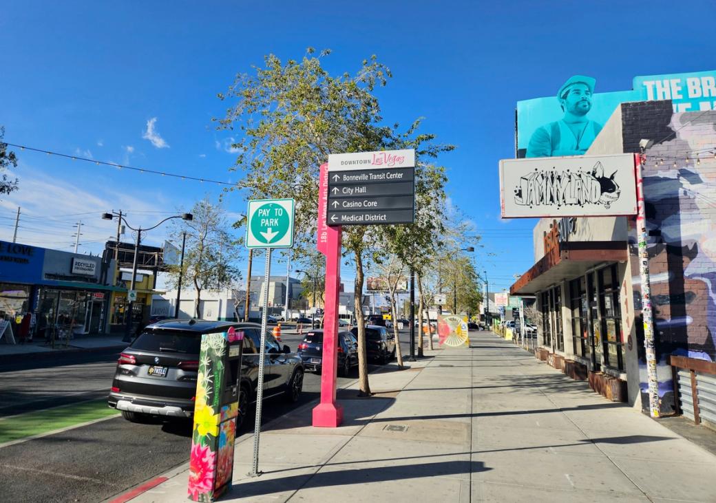 A street with pink sign posts.