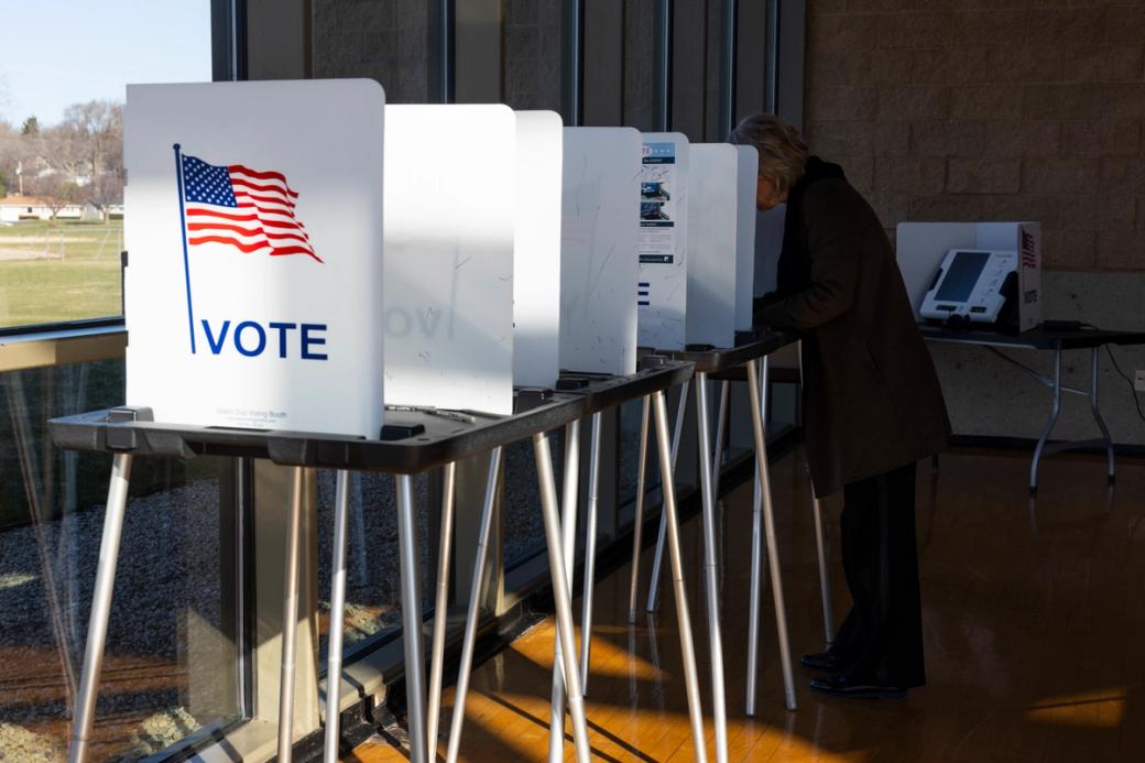 Voting booths at Warner Park Community Recreation Center during last month's election, with a person voting at one of them.