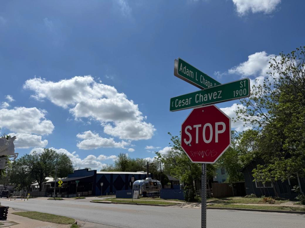 A stop sign that has a "Cesar Chavez Street" sign on it.