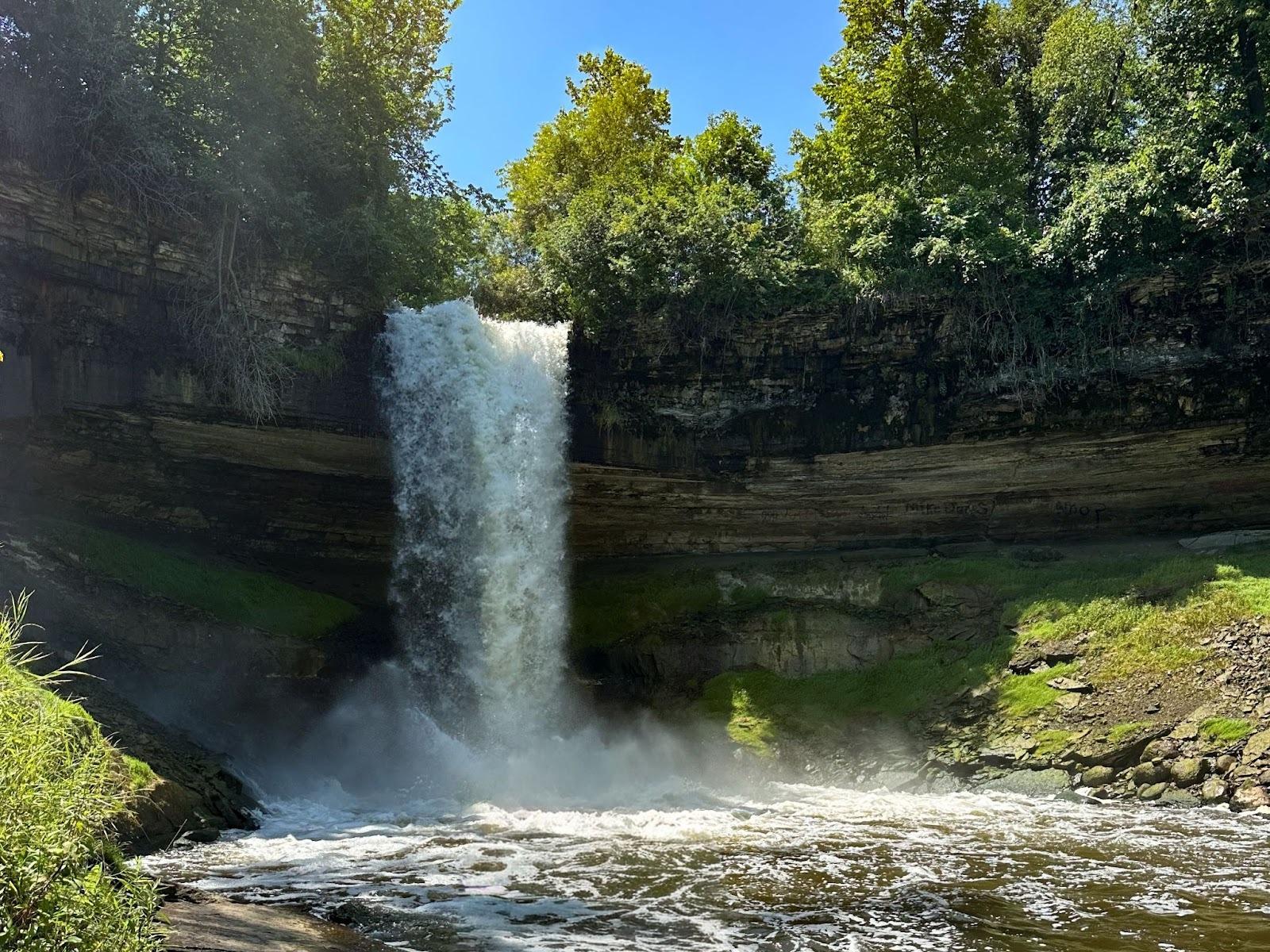 A waterfall falling over a cliff into a river