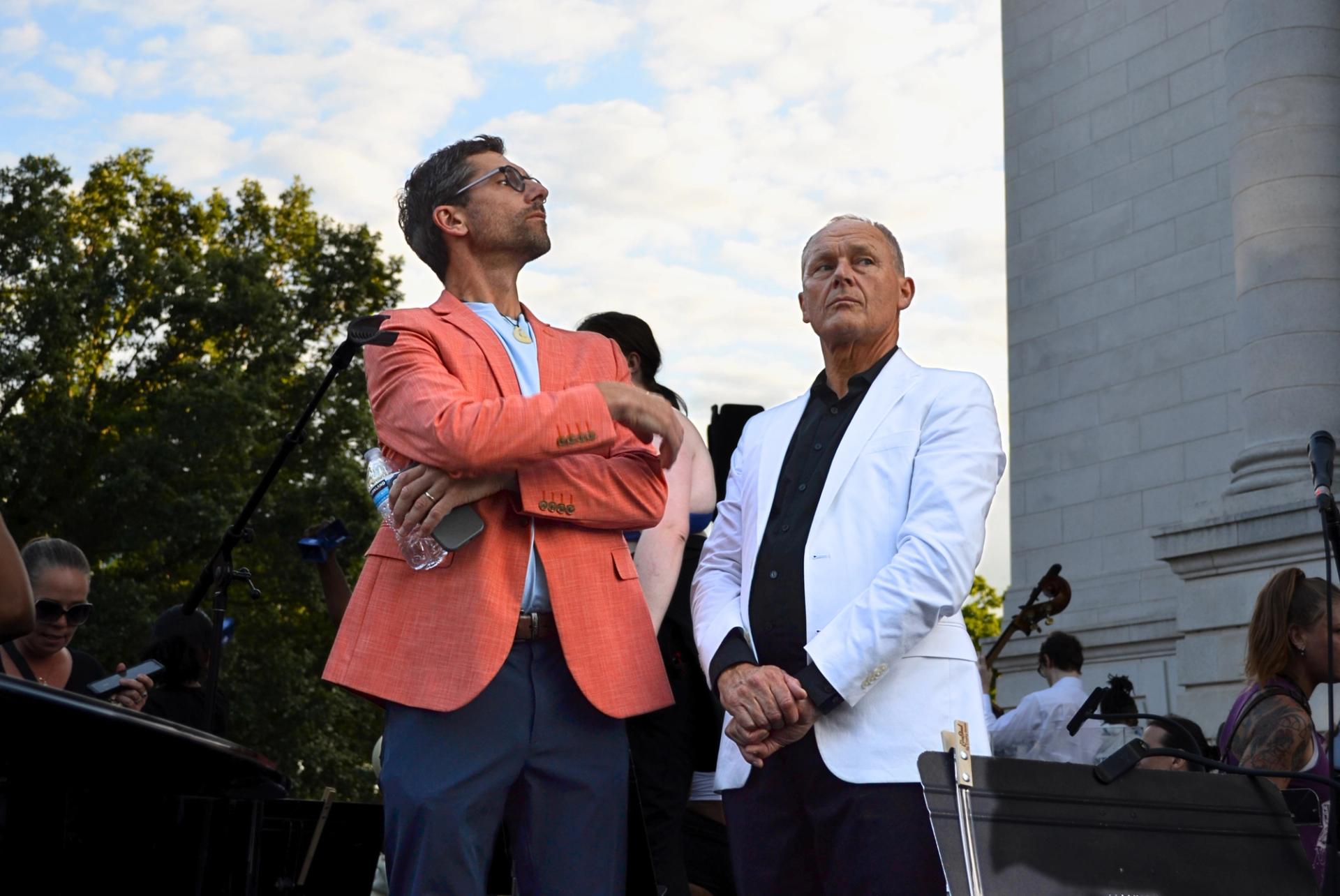 A man in an orange jacket and a man in a white jacket.