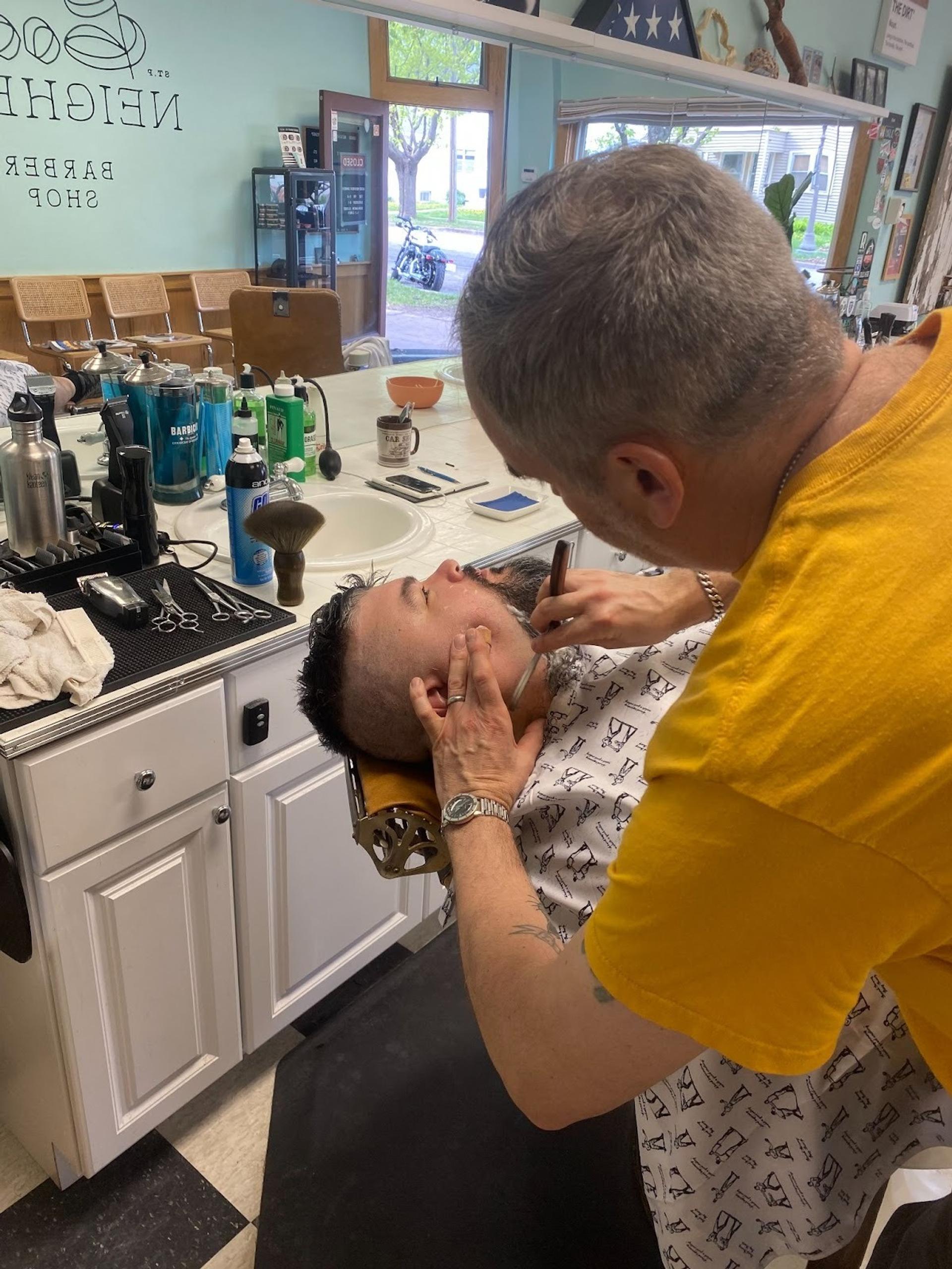 a barber doing a straight razor shave