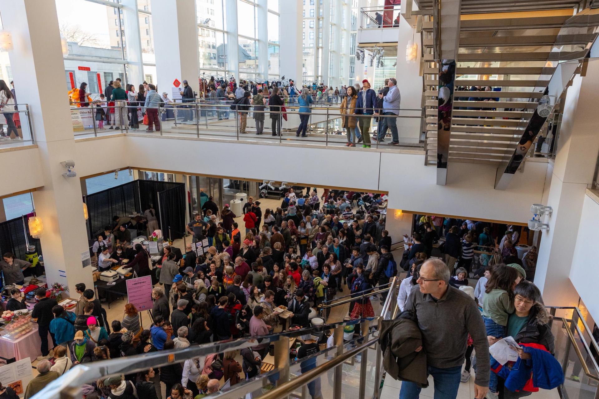 A crowd of people in an indoor lobby.