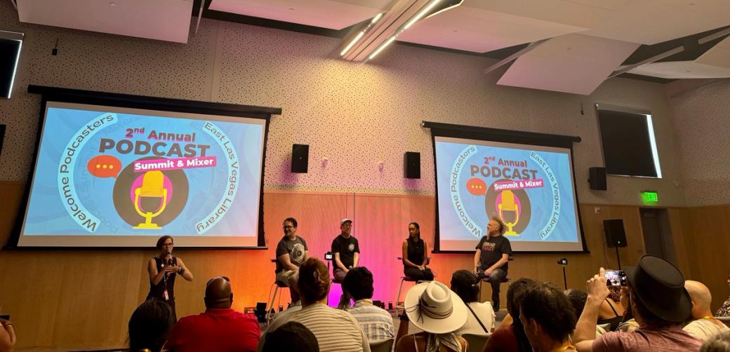 A panel of speakers inside a conference room.