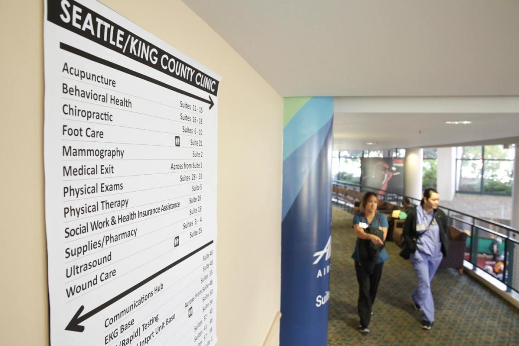 A sign listing various health services is pictured as people receive free dental, vision, and medical care during the Seattle/King County Clinic at the Key Arena in Seattle, Washington
