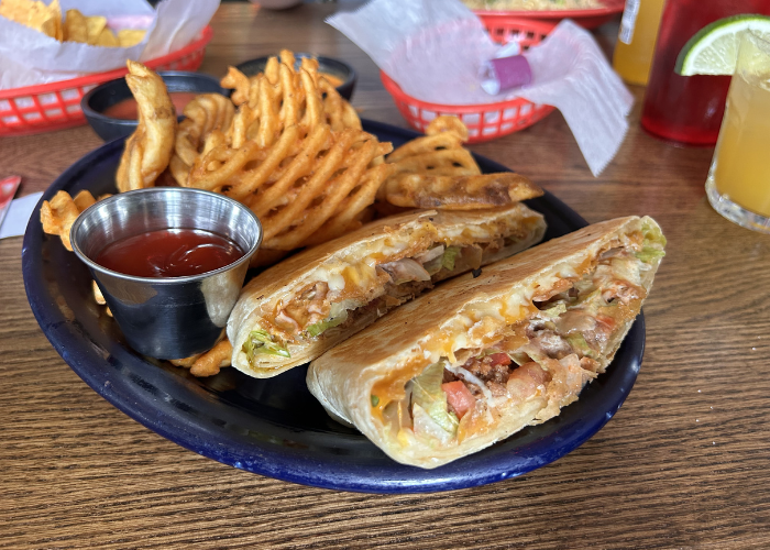 A plate with tacos and waffle fries.