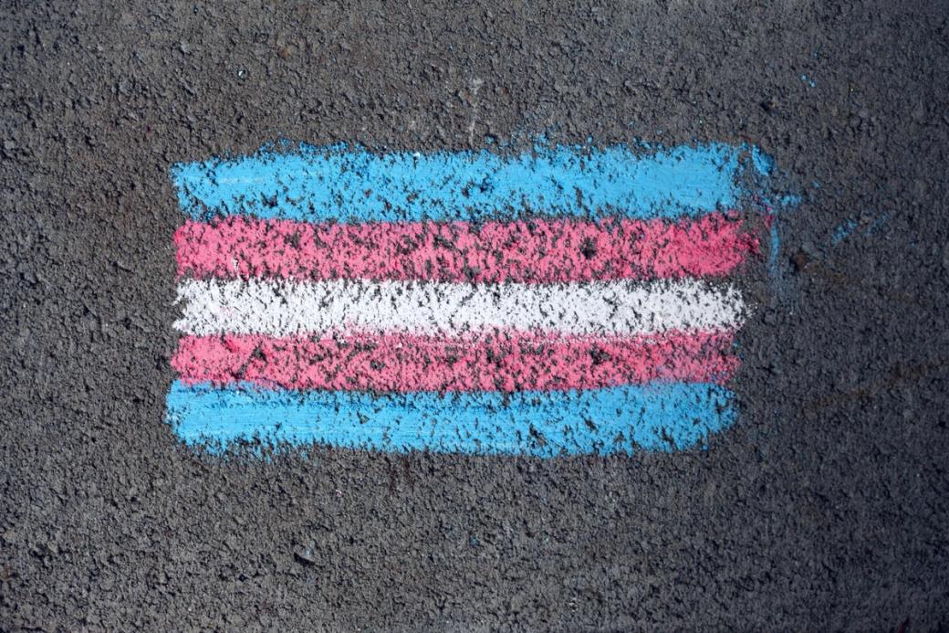 A chalk drawing of a flag with five horizontal stripes in light blue, pink, and white.