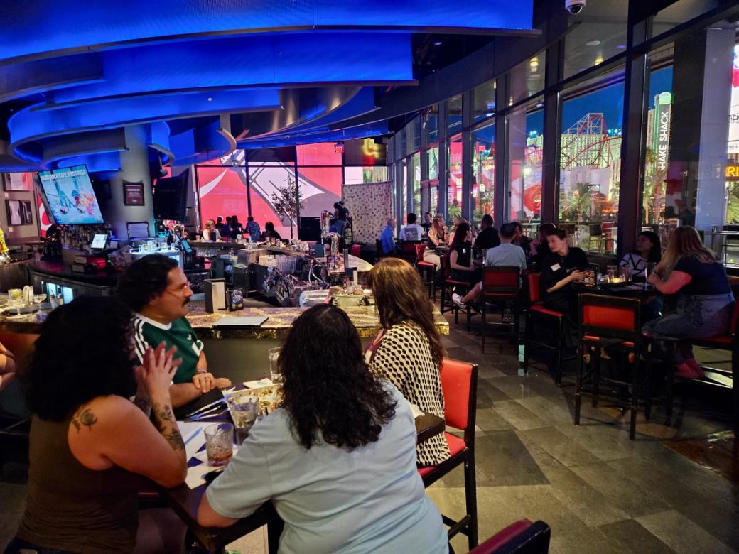 A group of people sit at tables in the Hard Rock Cafe.