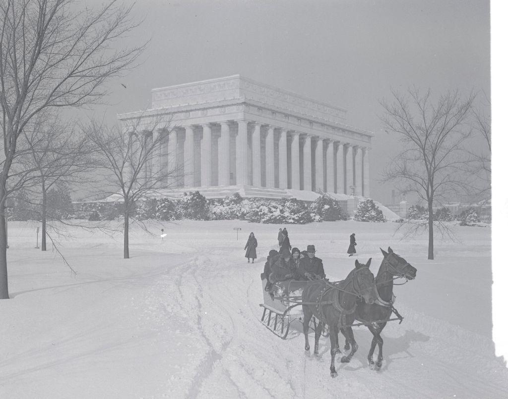Horse-driven sleigh on a snowy path near the Lincoln Memorial