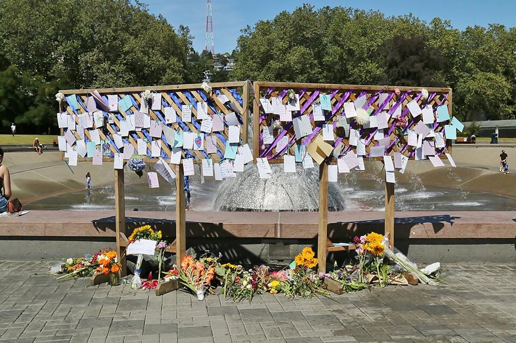 The international fountain at Seattle Center is surrounded by notes and cards attached to two wooden structures