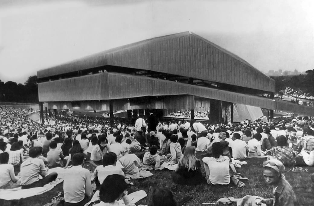 Concertgoers sit outside at the Mann