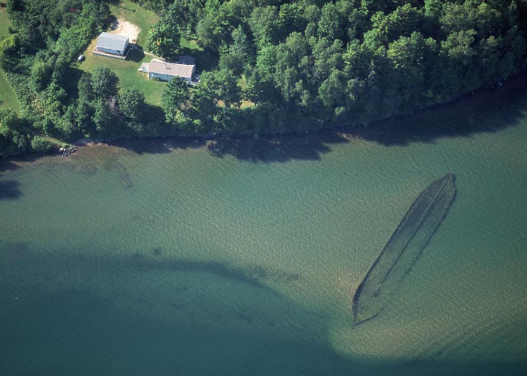 An aerial view of Lake Superior showing a sunken canoe under blue-green water.