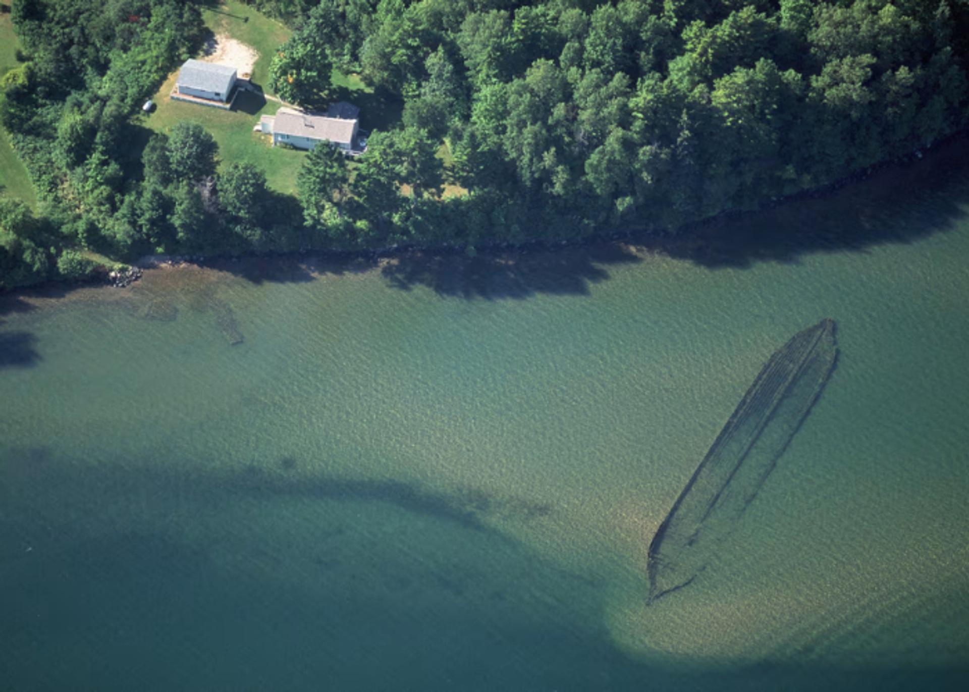 An aerial view of Lake Superior showing a sunken canoe under blue-green water.