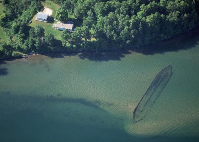 An aerial view of Lake Superior showing a sunken canoe under blue-green water.
