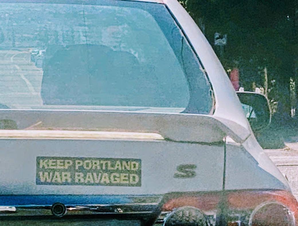 Picture of a car with a bumper sticker that reads "Keep Portland War Ravaged"