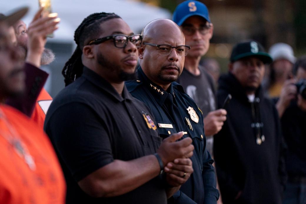 An image of Shon Barnes and others at a vigil the day after the Bite of Seattle shooting. He is standing with community members