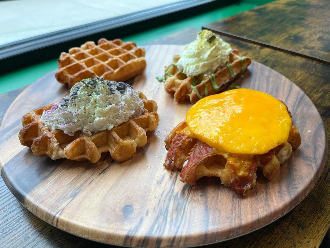 A circular board with four waffles on top.