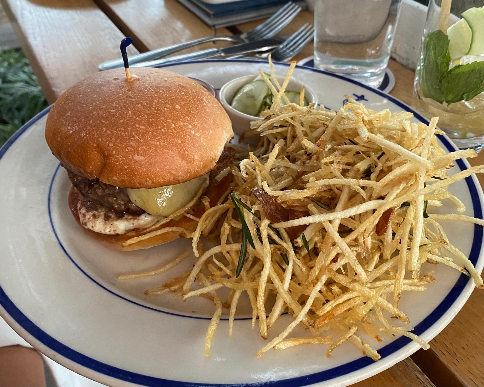A cheeseburger and fries on a white plate.