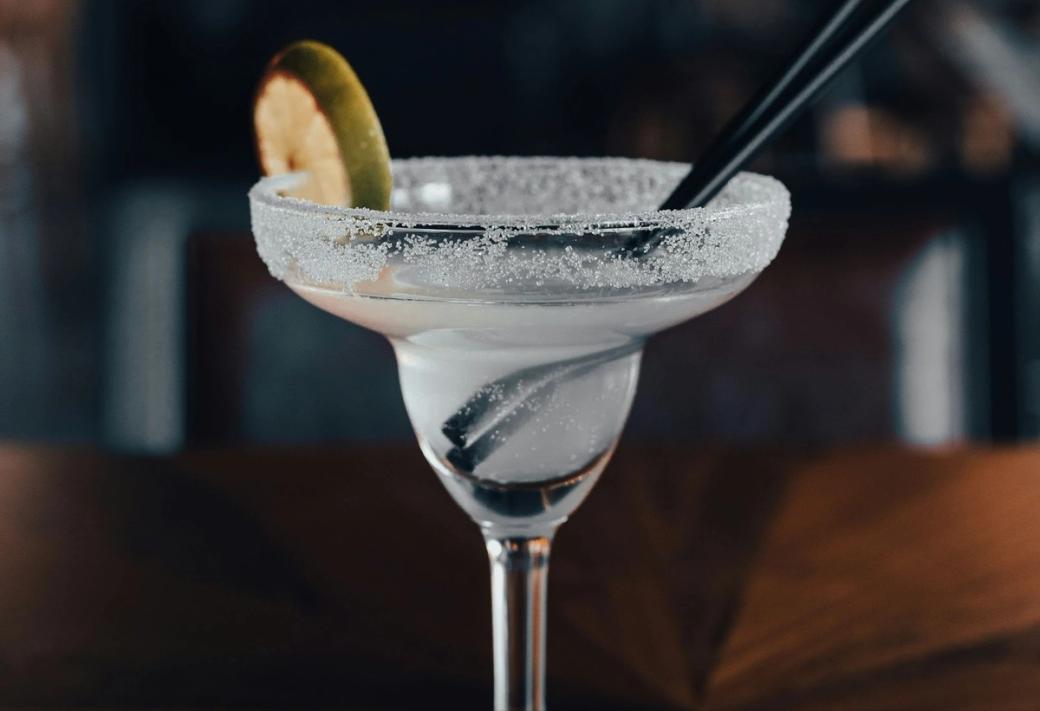  A margarita with salt on the rim and wedge of lime.