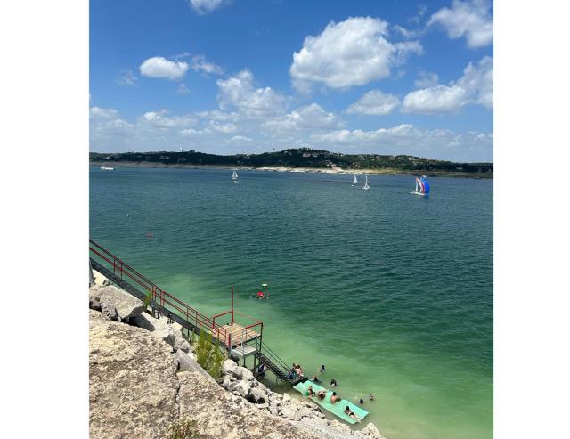 A lake filled with dark blue water and a set of stairs on the side of a rocky cliff.