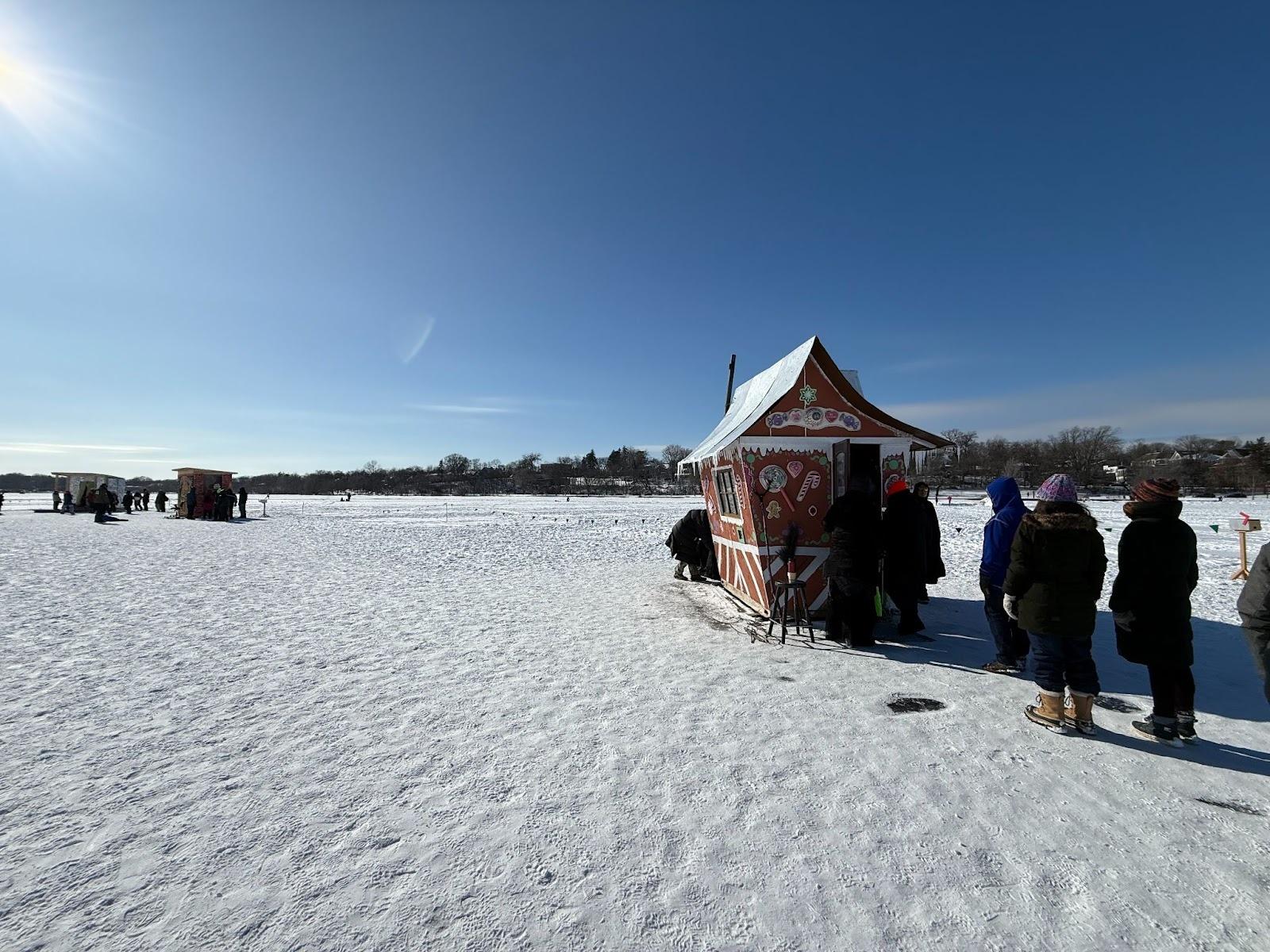 A snowy ground with a gingerbread house popup in the middle