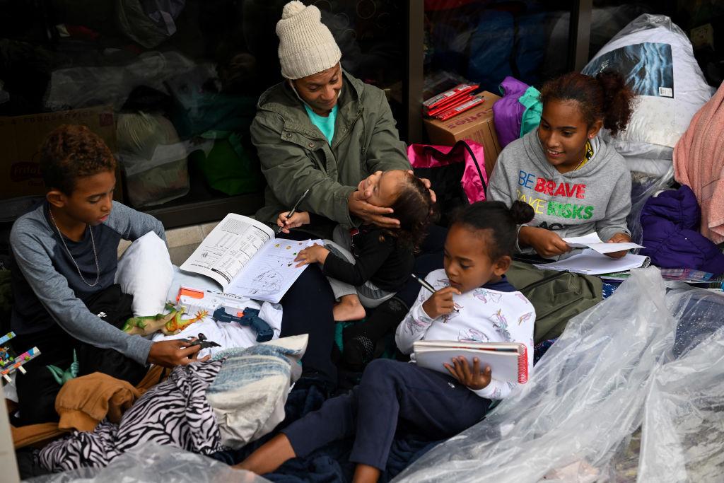 Migrant mother Marioxi Leon with her family at the 15th District police station Sept. 11