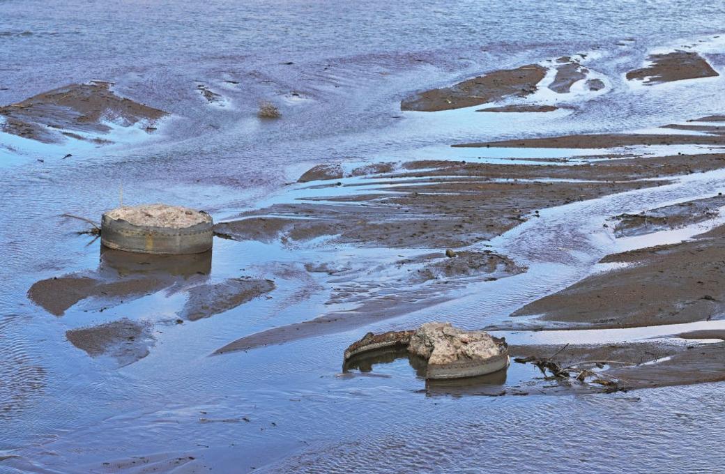 closeup image of concrete chunks and mud in the Arkansas River near Pueblo, Colorado.