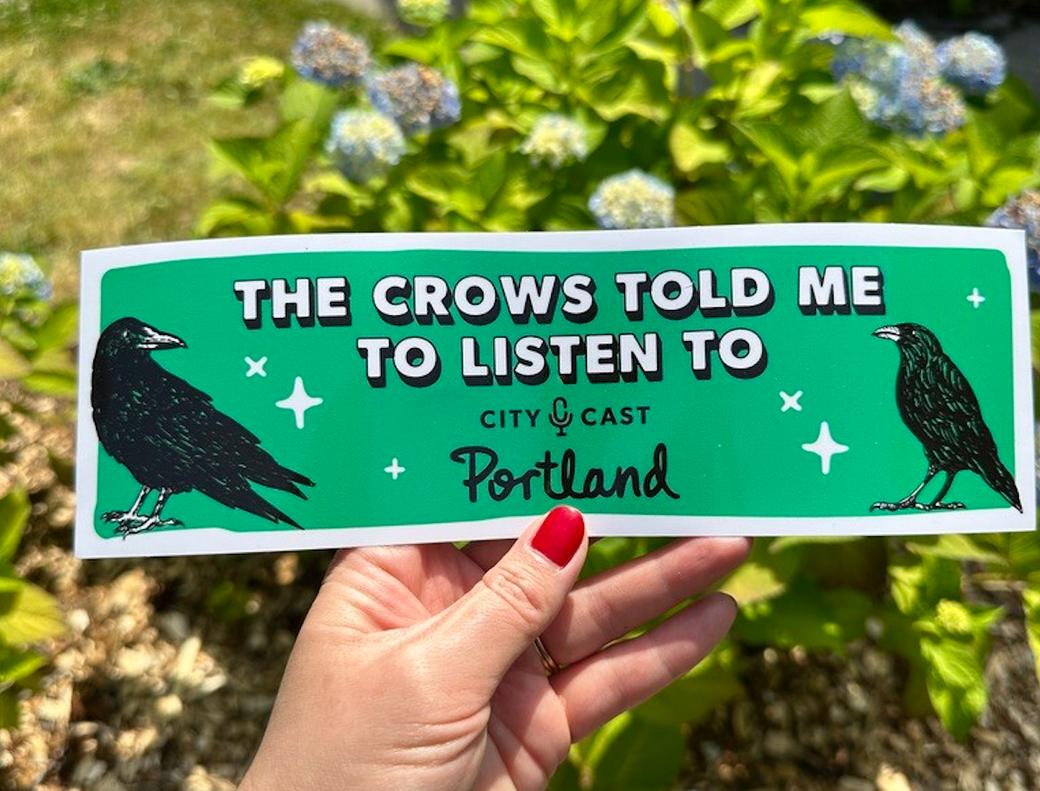 Green bumper sticker with two black crows that reads “The Crows Told Me to Listen to City Cast Portland”
