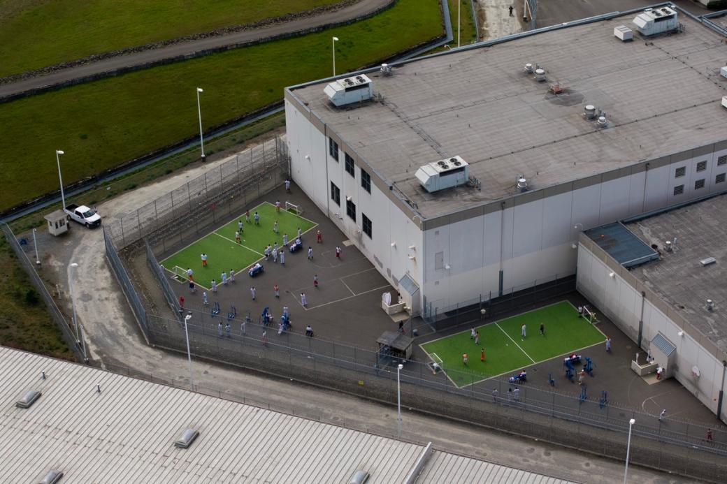 A photo from the air of the Northwest ICE Processing Center and recreation yard with inmates milling around