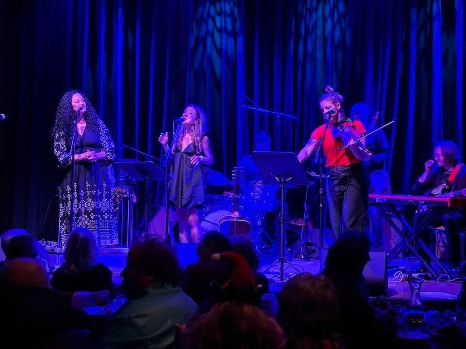 A group of people on stage playing instruments and singing
