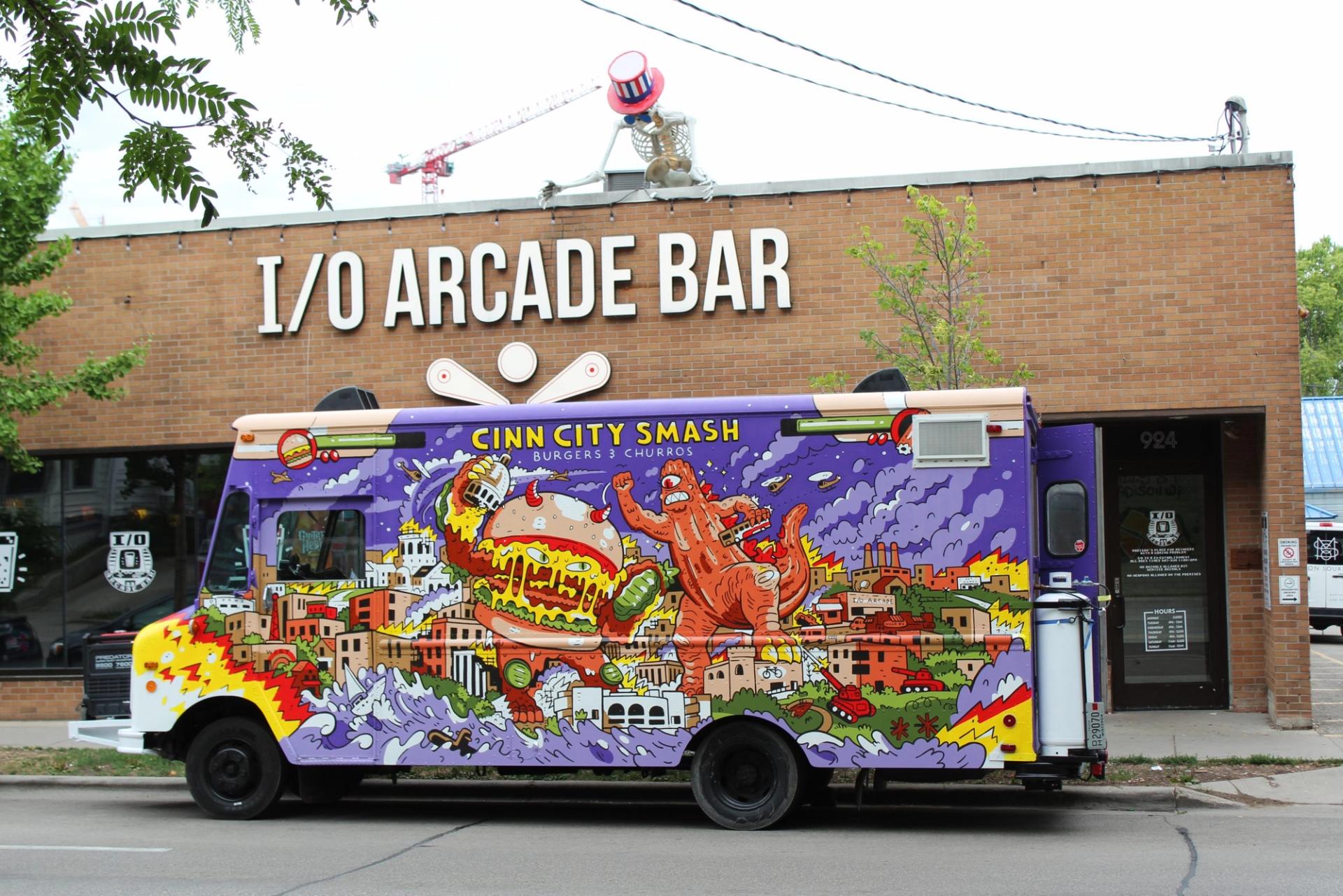 A purple truck in front of a brown building.