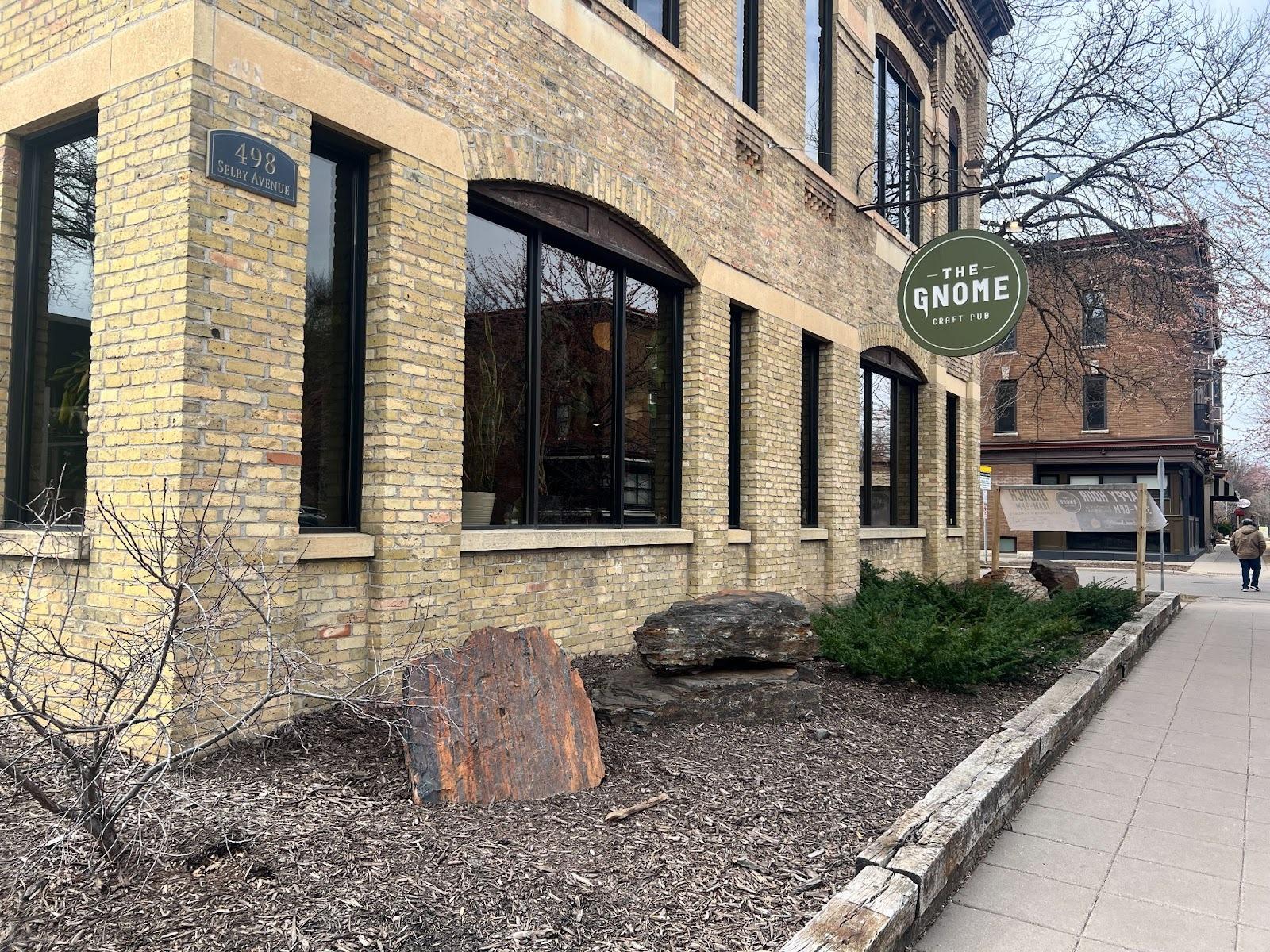 A brick building with a sign coming out that says "Gnome Craft Pub"