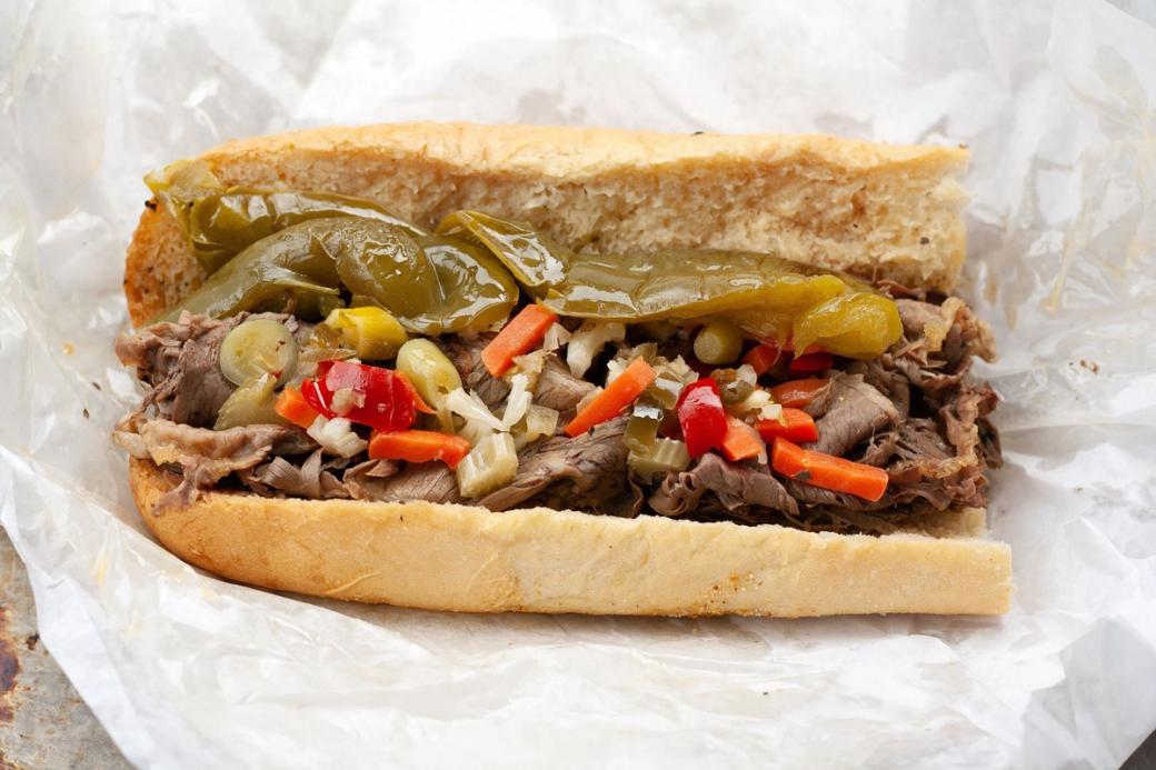 An italian beef sandwich with peppers, onions, carrots on bread