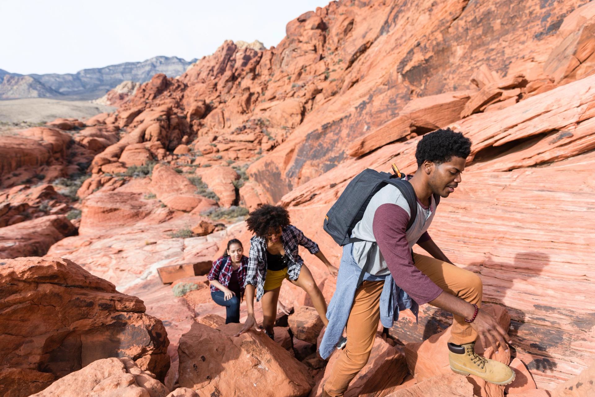 Photo of people hiking on desert rockscape.