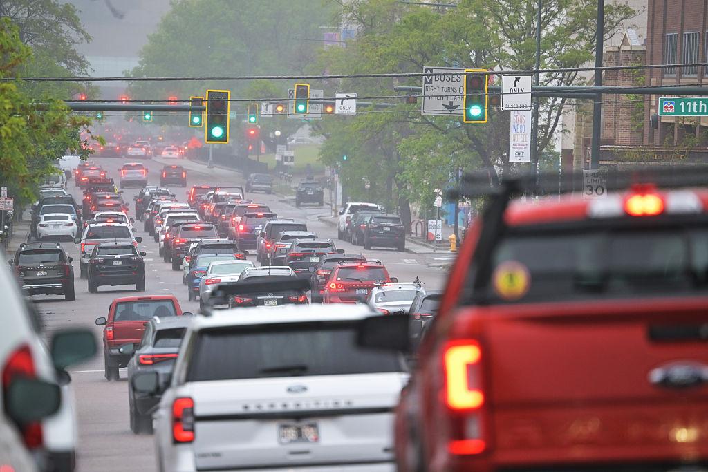 Dozens of cars driving in heavy traffic on a multi-lane Denver street
