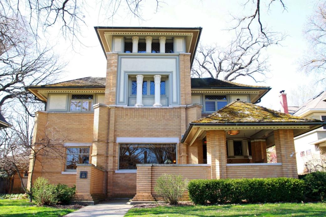 A tall three story house with a green front yard