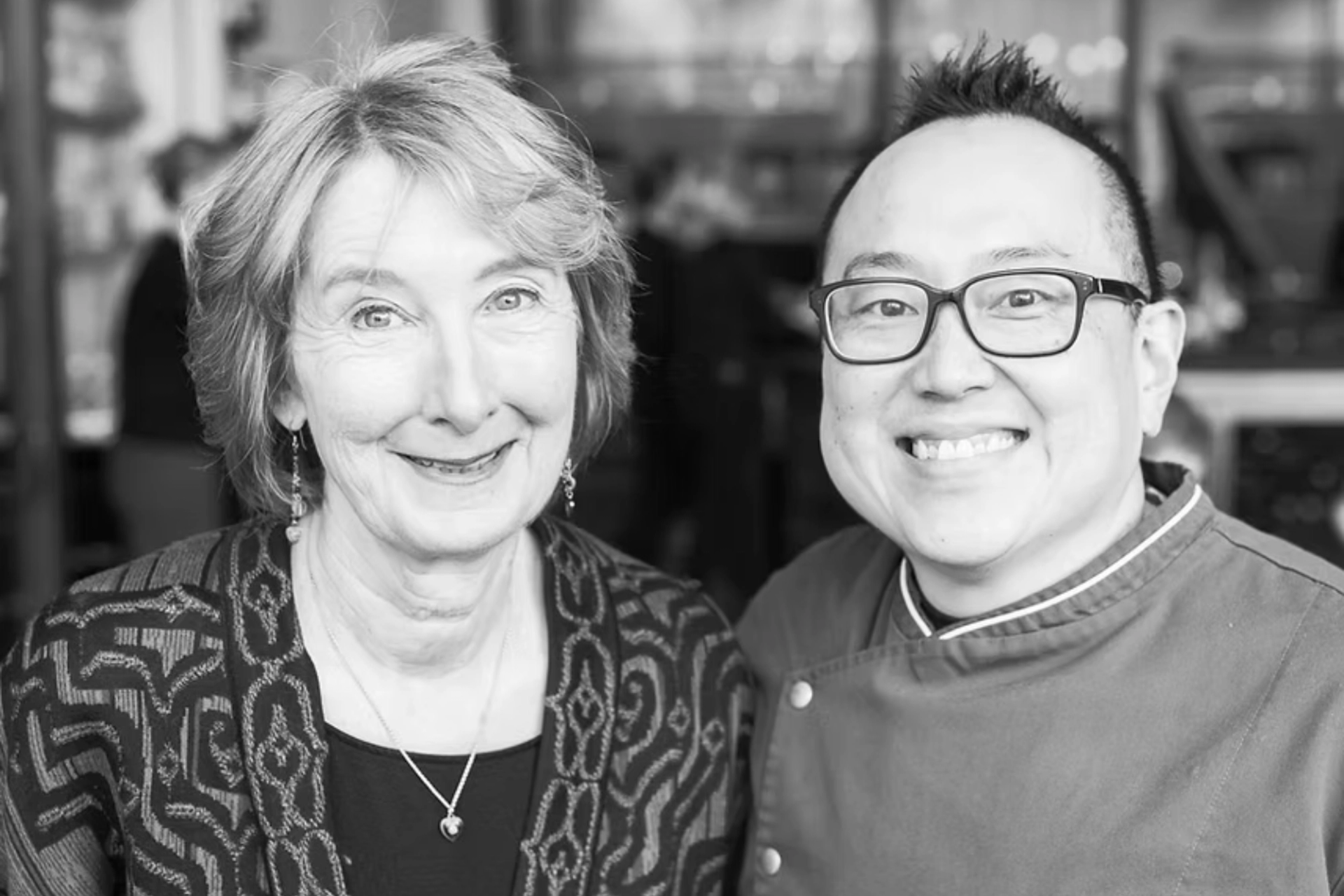 A black-and-white photo of a smiling woman and man.