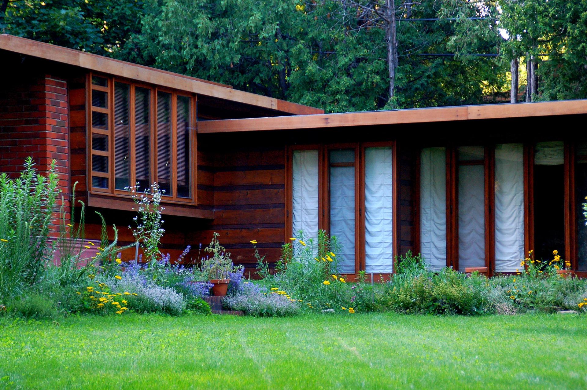 A boxy brown house on a green lawn. 