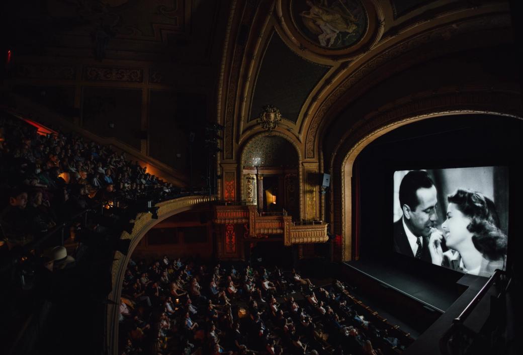 A theater with a black and white image of a man and woman on the screen.