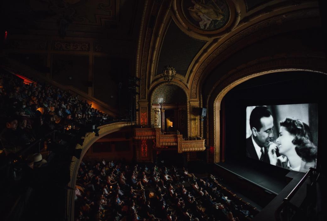 A theater with a black and white image of a man and woman on the screen.