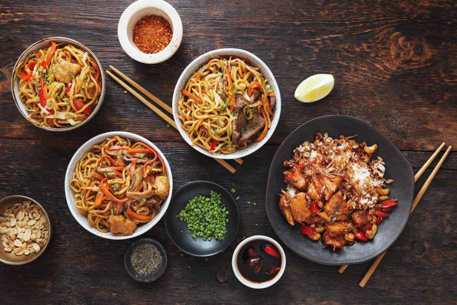 bowls of Asian noodle dishes laid out on a table